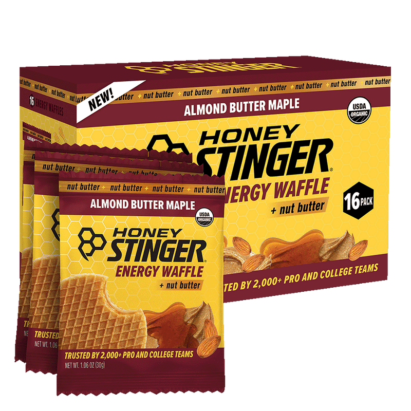 Box of Honey Stinger Almond Butter Maple Energy Waffles with multiple packages stacked on top.