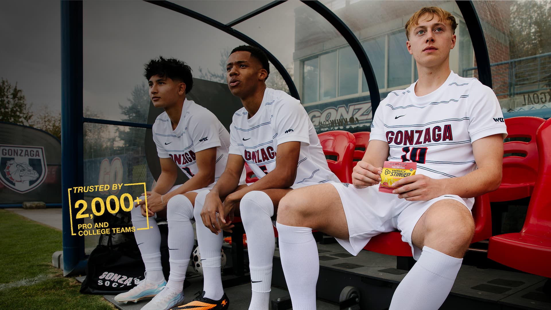 Gonzaga soccer players enjoying Honey Stinger Chews on the sideline - trusted by 2,000 pro and college teams