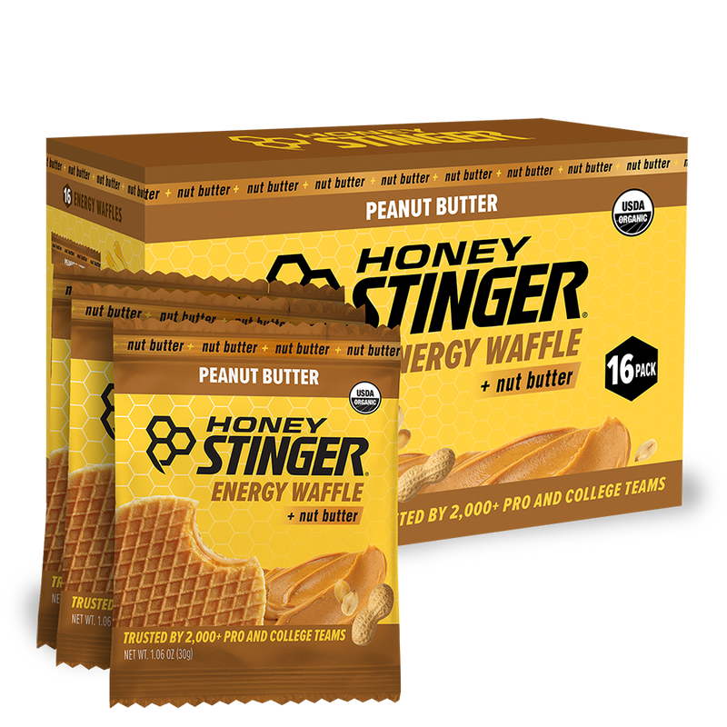 Honey Stinger Peanut Butter Energy Waffle packaging with a box of 16 packs on a white background