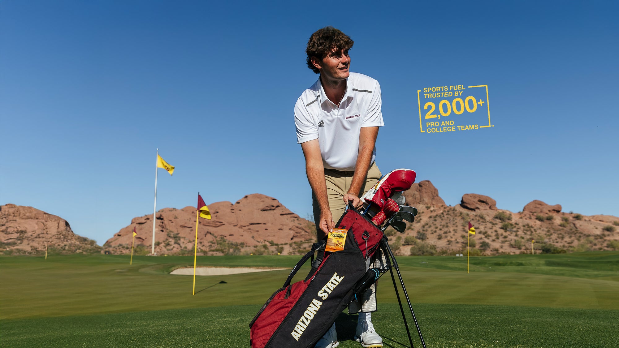 Man on a golf course with a red bag and a scenic background