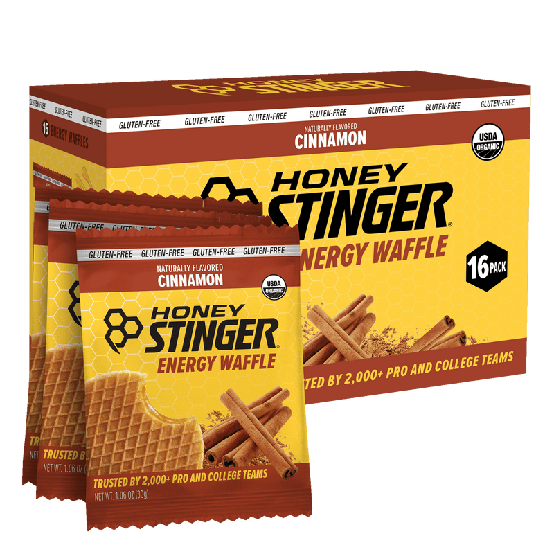 Honey Stinger Cinnamon Energy Waffle packaging with a box of 16 packs on a white background.