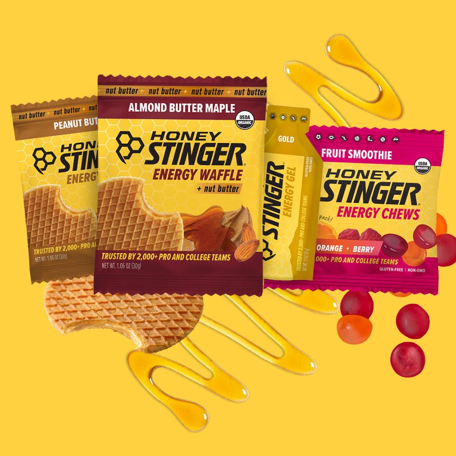 Honey Stinger energy waffle, energy chews, and honey on a yellow background